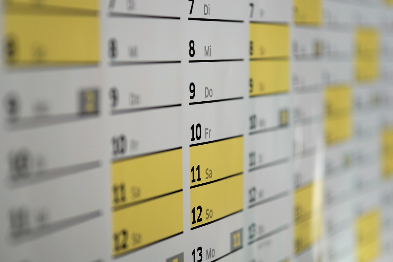 un calendrier annuel avec deux colonnes, l'une rouge et l'autre bleue, représentant les périodes de garde des enfants par chaque parent dans le cadre d'une séparation ou d'un divorce. Les mois de 2022 et 2023 sont visibles sur le calendrier